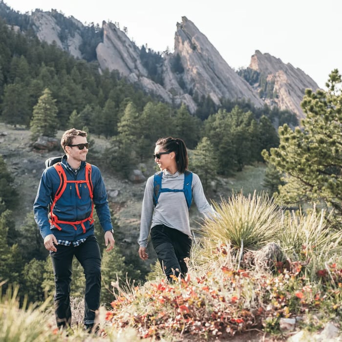 pareja caminando en las montañas realizando senderismo con mochilas thule alltrail