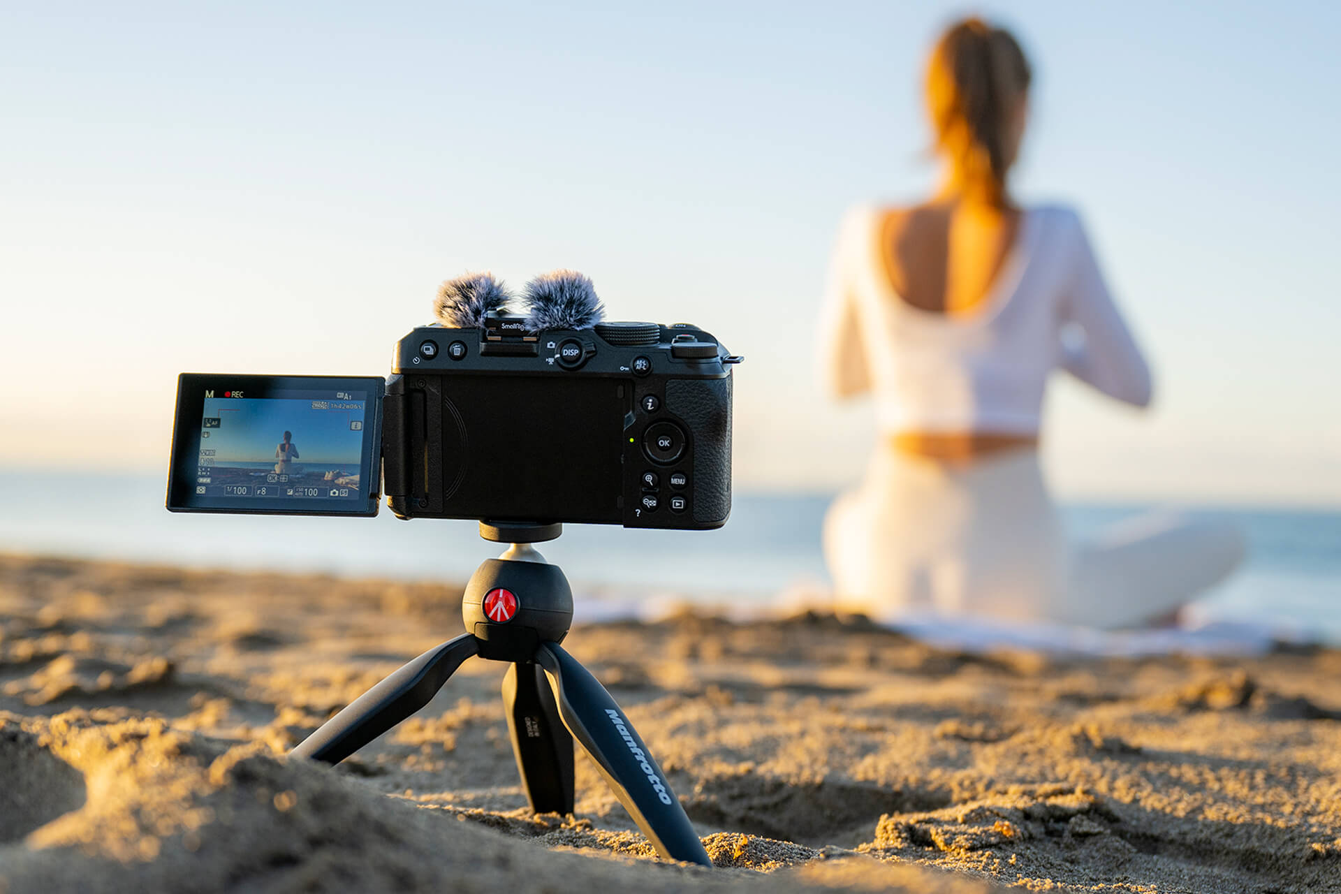 câmera nikon z30 apontando para mulher sentada na praia 
