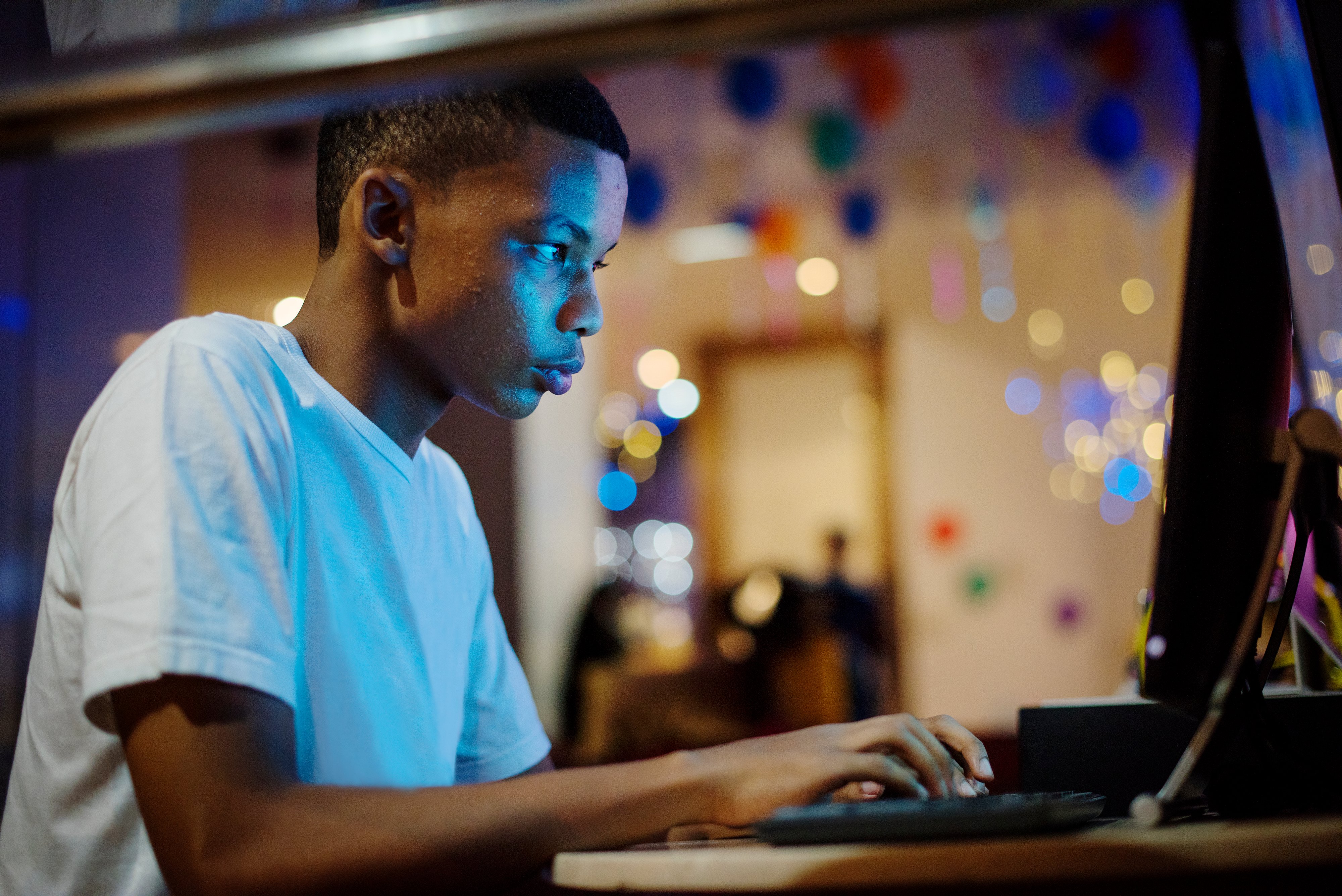 african-american-boy-using-a-computer-at-night-2022-09-16-09-21-59-utc