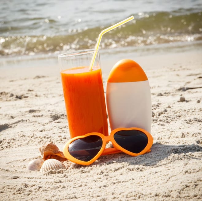 suco de cenoura e protetor solar na praia