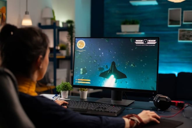 mulher jogando no computador sobre a mesa gamer