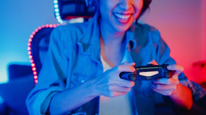mulher feliz jogando playstation na sua mesa gamer