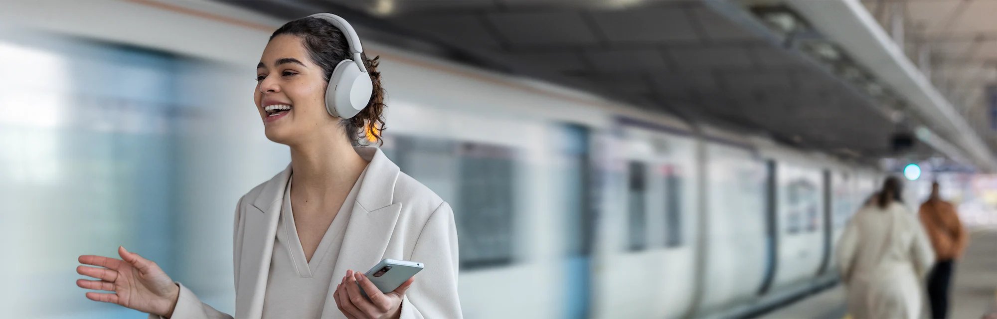 mulher no metro usando fone Sony WH-1000XM5